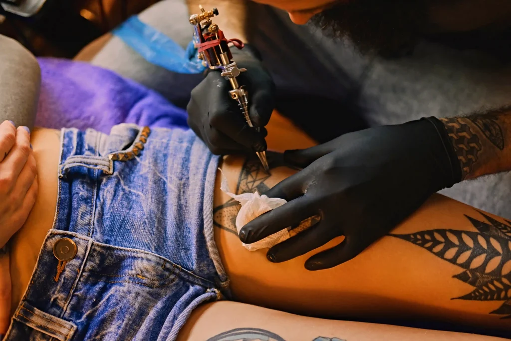 close-up-image-bearded-tattoo-male-artist-makes-tattoo-female-leg