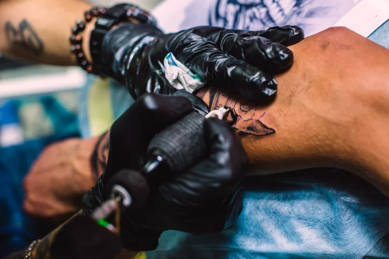 hands-drawing-tattoo-arm-with-needle-machine