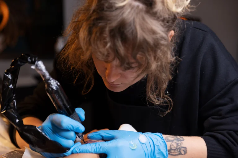 high-angle-tattoo-artist-working