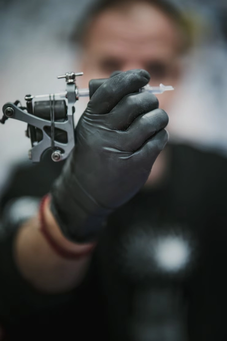tattoo-artist-holding-looking-tattoo-machine